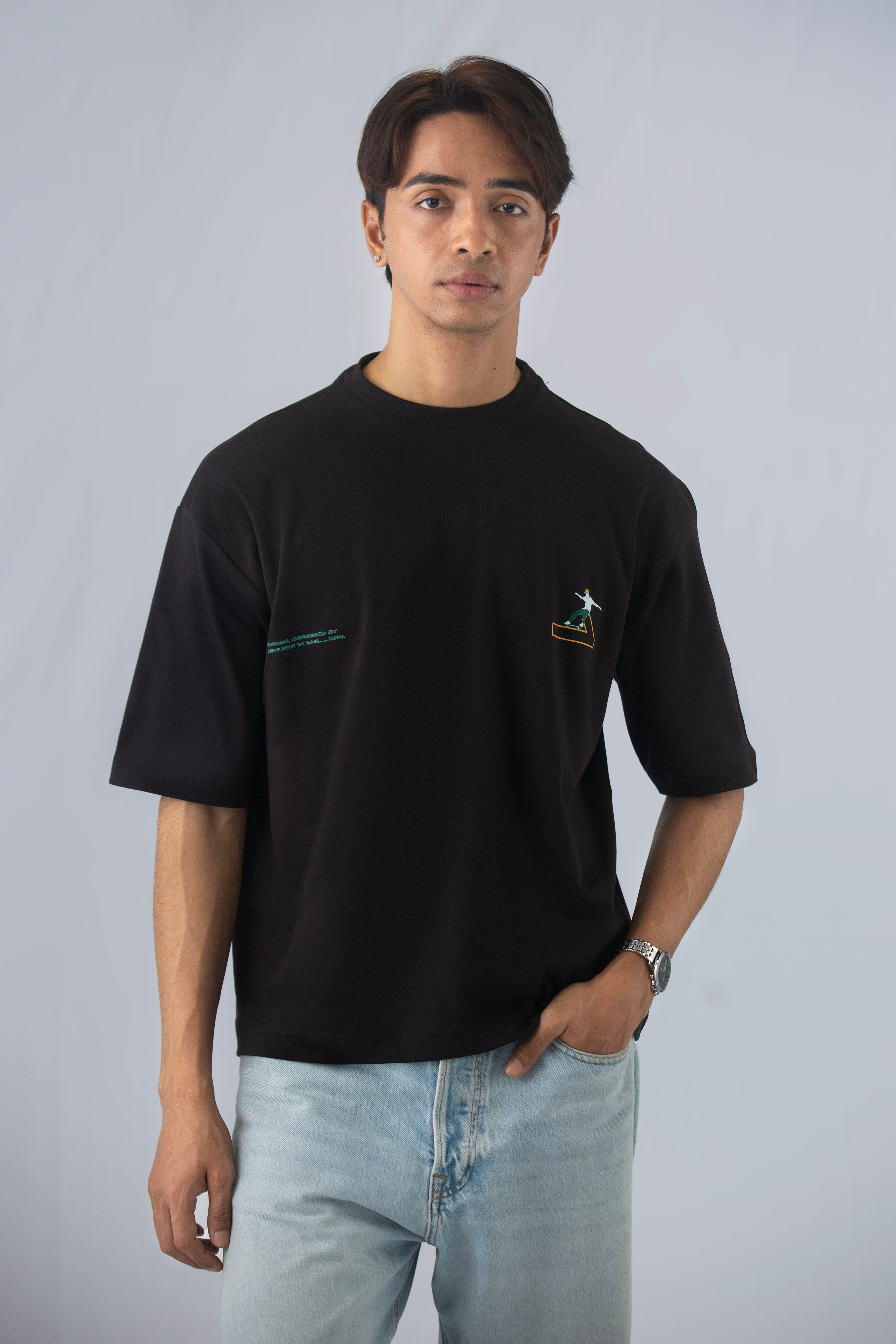 A person wearing a black oversized printed t-shirt and light blue jeans.